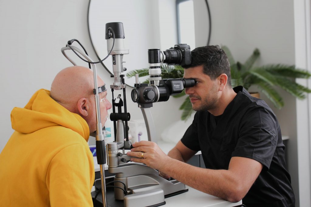 Ophtalmologue réalisant un examen visuel complet avec lampe à fente sur un patient, avant une chirurgie réfractive au laser.
