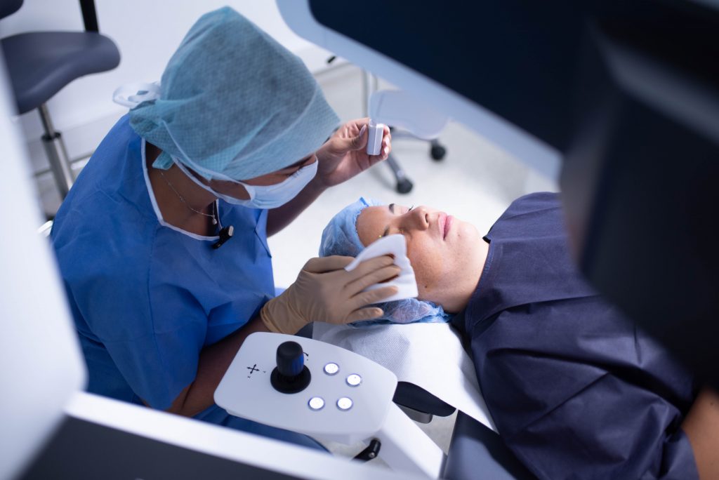 Une optométriste met des gouttes dans les yeux pour préparer sa patiente pour une chirurgie laser de la myopie.
