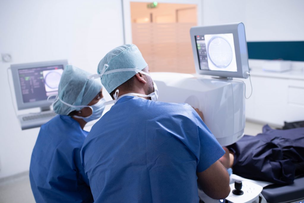 Deux chirurgiens ophtalmologue effectuent une chirurgie réfractive avec un équipement laser.